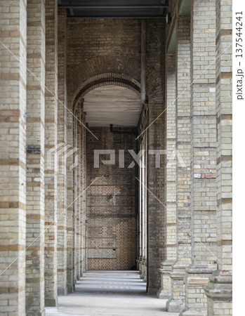 The arcade stretched out like a rhythmic countdown of stone and shadow. Each weathered pillar, stained with the pale gold of a low sun, stood as a silent witness to the years. The air felt heavy with The arcade stretched out like a rhythmic countdown of stone and shadow. Each weathered pillar, stained with the pale gold of a low sun, stood as a silent witness to the years. The air felt heavy with 137544241