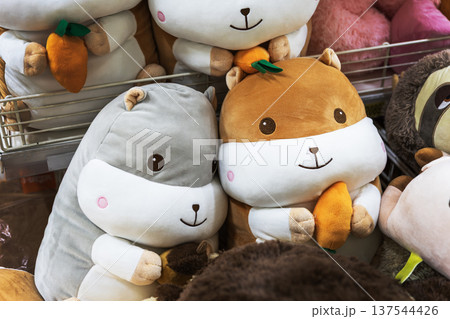 Cute hamster plush toys with carrots and acorns on a store shelf. Cute hamster plush toys with carrots and acorns on a store shelf. 137544426