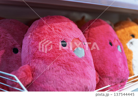 Macro shot of bright pink and orange plush toys on a retail shelf. Macro shot of bright pink and orange plush toys on a retail shelf. 137544445