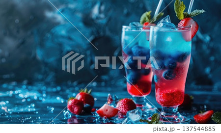 Two colorful cocktails with ice, blueberries, and strawberries on a blue background. Refreshing summer drinks with mint leaves. copy space, free space for text 137544885