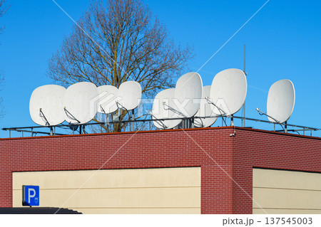Multiple Satellite Dishes Installed on Building Roof for Telecommunications and Broadcasting 137545003