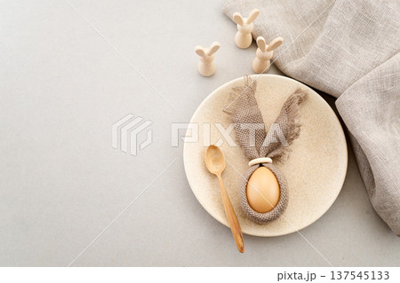 Zero waste Easter. Easter table setting with egg bunny and wooden rabbits Zero waste Easter. Easter table setting with egg bunny and wooden rabbits 137545133