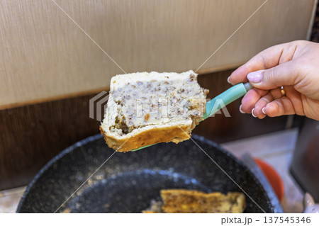 Hand holding a slice of traditional Ukrainian buckwheat and potato pie. 137545346