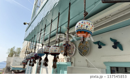 Colorful ceramic lanterns hanging on a shop facade in a coastal town setting Colorful ceramic lanterns hanging on a shop facade in a coastal town setting 137545853