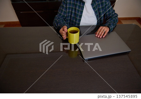 Woman Entrepreneur Working From Home With Laptop And Coffee In Casual Clothes Woman Entrepreneur Working From Home With Laptop And Coffee In Casual Clothes 137545895