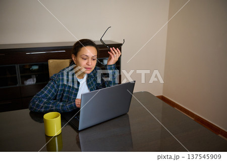 Woman Entrepreneur Working From Home With Laptop Telecommuting in Casual Clothing Woman Entrepreneur Working From Home With Laptop Telecommuting in Casual Clothing 137545909