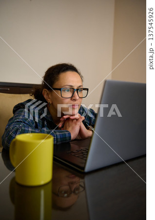 Woman Entrepreneur Working From Home On Laptop Telecommuting Remotely With Coffee Cup 137545926