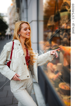 Woman window shopping in Vienna pointing at store display 137546009