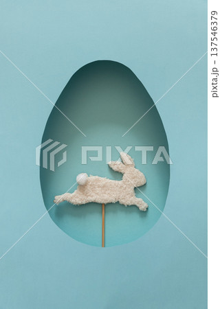 Easter Egg Cut Out with Bunny Silhouette on blue Background. Festive Spring Composition Easter Egg Cut Out with Bunny Silhouette on blue Background. Festive Spring Composition 137546379