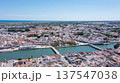 Tavira in Algarve is seen from above with traditional buildings lined along the Gilao river. The coastline and countryside can be observed in the distance 137547038