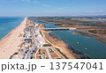 Aerial view captures Praia de Faro and Ria Formosa, displaying the beach, town, bridges, and water during a sunny day 137547041