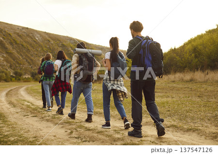 Tourist people walking rear, outdoor hiking travelling group going on countryside trail, footpath Tourist people walking rear, outdoor hiking travelling group going on countryside trail, footpath 137547126