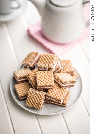Stack of Chocolate Wafer Cookies on Plate With Layered Cream Filling, Crispy Dessert Snack 137547657