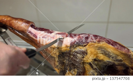 Authentic spanish ham being expertly sliced for traditional culinary experience 137547708