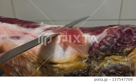 Traditional spanish ham slicing technique close-up for culinary inspiration Traditional spanish ham slicing technique close-up for culinary inspiration 137547709