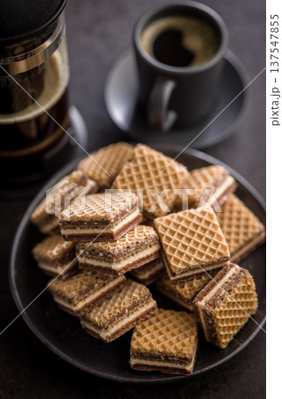 Stack of Chocolate Wafer Cookies on Plate with Coffee Cup and French Press Stack of Chocolate Wafer Cookies on Plate with Coffee Cup and French Press 137547855