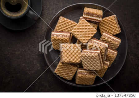 Stack of Chocolate Wafer Cookies on Plate with Coffee Cup and French Press 137547856