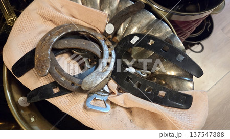 Vintage finds at an outdoor flea market displaying horseshoes and metal artifacts 137547888