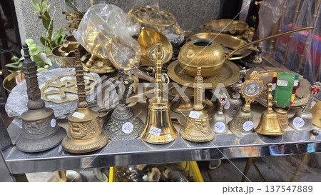 Antique bells and brassware display at a flea market for vintage collection and home decor. Rastro. Madrid. Spain Antique bells and brassware display at a flea market for vintage collection and home decor. Rastro. Madrid. Spain 137547889
