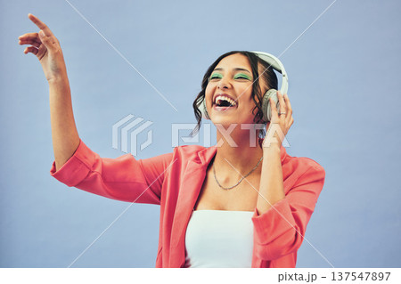 Fashion, music and happy woman dance in studio with trendy, clothes and feel good audio on blue background. Style, smile and female model with freedom, energy or moving to radio, streaming or podcast Fashion, music and happy woman dance in studio with trendy, clothes and feel good audio on blue background. Style, smile and female model with freedom, energy or moving to radio, streaming or podcast 137547897