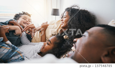 Family, laughing and living room with kids, father and love together in a home in bed. Mother, relax and children with dad and funny joke with bonding, support and care in house with happy people 137548785