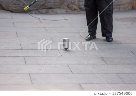 Man whipping spinning tops, traditional Chinese game Man whipping spinning tops, traditional Chinese game 137549006