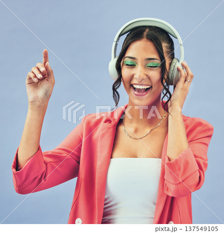 Music, headphones and happy woman dance in studio with podcast, track or audio subscription on blue background. Face, smile and lady model with freedom, energy or moving to radio or feel good podcast Music, headphones and happy woman dance in studio with podcast, track or audio subscription on blue background. Face, smile and lady model with freedom, energy or moving to radio or feel good podcast 137549105