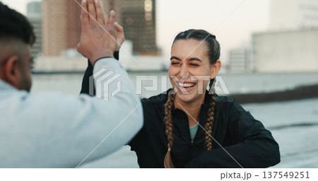 Happy couple, celebration or high five on rooftop for fitness exercise or workout together with pride or smile. Athletes, motivation or excited or man with woman, support or goal on building in city 137549251