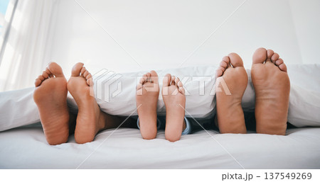 Sleeping, feet and family in a bed with love, relax and resting in comfort in their home together. Barefoot, care and child with mom, father and security in bedroom for sleep, bonding and weekend nap 137549269