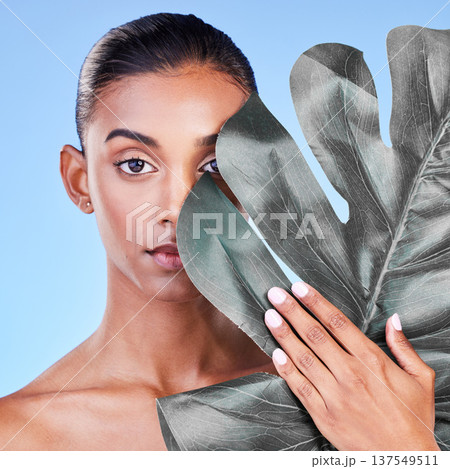 Natural beauty, woman and face, monstera leaf and glow with wellness and eco friendly dermatology on blue background. Sustainable skincare, green with collagen and cosmetics in portrait in studio 137549511