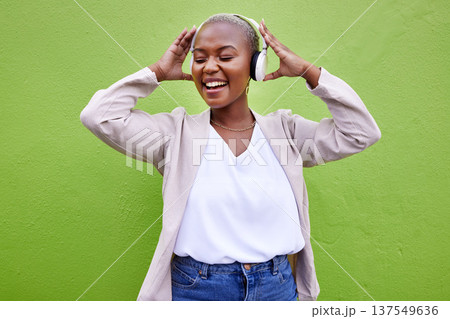 Music, headphones and black woman dance on green wall background mockup space. Radio, singing and happy African person streaming podcast, hearing audio or listening to sound of jazz media for freedom 137549636