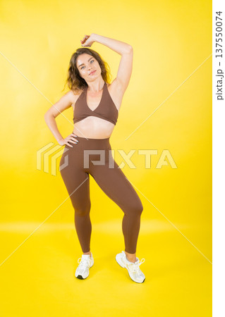 Woman posing in brown athletic wear, feeling confident 137550074