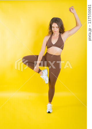 Woman balancing in athletic wear practicing yoga pose Woman balancing in athletic wear practicing yoga pose 137550081