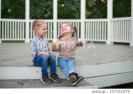 Children sitting and eating snacks in park gazebo Children sitting and eating snacks in park gazebo 137551079
