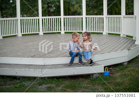Children sitting and eating snacks in park gazebo Children sitting and eating snacks in park gazebo 137551081