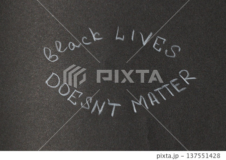 A message of protest and social justice written in chalk on a dark, textured background, conveying a powerful statement 137551428
