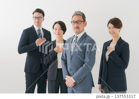 胸に手を当てる複数のビジネスマン 胸に手を当てる複数のビジネスマン 137553317