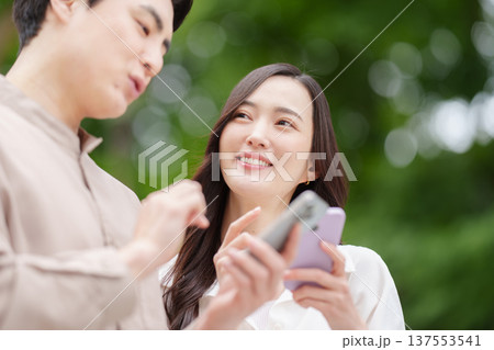 スマホで目的地を検索するカップル スマホで目的地を検索するカップル 137553541
