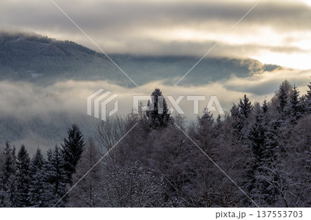 Sunrise makes a breakthrough in the mist between the mountains Sunrise makes a breakthrough in the mist between the mountains 137553703