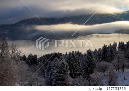 Sunrise makes a breakthrough in the mist between the mountains Sunrise makes a breakthrough in the mist between the mountains 137553736