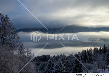 Sunrise makes a breakthrough in the mist between the mountains Sunrise makes a breakthrough in the mist between the mountains 137553740