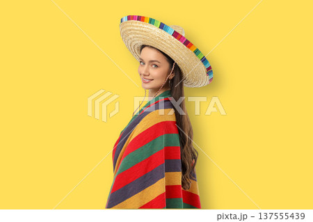Cinco de Mayo, A young woman wears a sombrero and a colorful blanket Cinco de Mayo, A young woman wears a sombrero and a colorful blanket 137555439