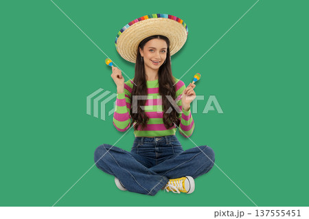 Cinco de Mayo, Young woman joyfully celebrating with maracas Cinco de Mayo, Young woman joyfully celebrating with maracas 137555451
