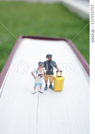 Two Tiny Figures Stand Together Beside Bright Suitcase Two Tiny Figures Stand Together Beside Bright Suitcase 137555757