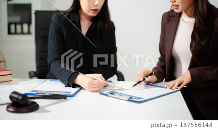 Business and lawyers discussing contract papers with brass scale on desk in office. Law, legal services, advice, justice and law 137556148
