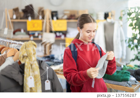 Teenage girl choosing hat in clothing store 137556287