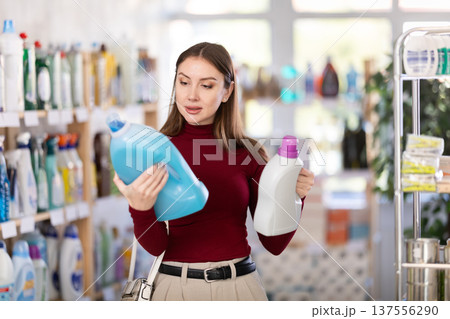 Young woman buyer chooses detergent in store 137556290