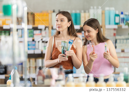 Woman and daughter choosing toothbrushes at the pharmacy Woman and daughter choosing toothbrushes at the pharmacy 137556332
