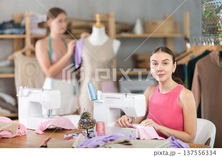 Adult woman sews female assistant working with mannequin 137556334