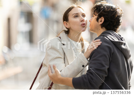Young couple kissing on city street Young couple kissing on city street 137556336